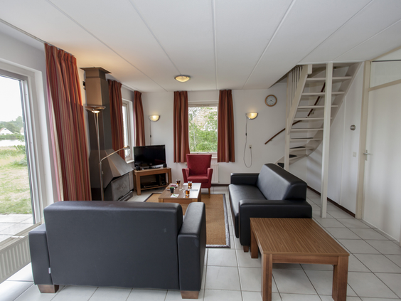 De gezellige en ruime woonkamer van een bungalow op Landal Natuurdorp Suyderoogh met een comfortabele zithoek.