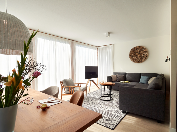 Stijlvol ingerichte woonkamer van een vakantievilla op Landal Puur Exloo, met een comfortabele zithoek en een ruime eettafel.