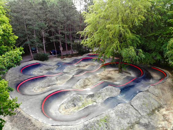 Grote pumptrack en crossbaan bij Landal Puur Exloo, perfect voor kinderen om te fietsen en te steppen in de bossen van Drenthe.