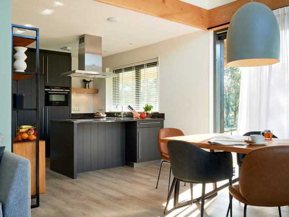 Moderne, volledig uitgeruste keuken met een kookeiland en eethoek in een luxe vakantievilla op Landal Puur Exloo.