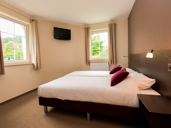 Comfortabele slaapkamer met opgemaakte bedden in een vakantiewoning van Landal Salztal Paradies in de Harz.
