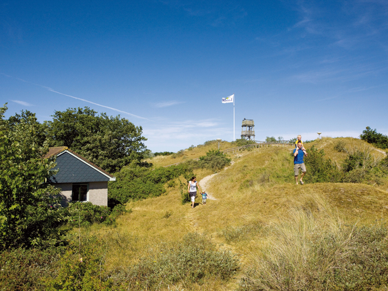 Kinderen rennen en spelen in het glooiende duinlandschap van natuurgebied de Slufter, direct naast vakantiepark Landal Sluftervallei op Texel.