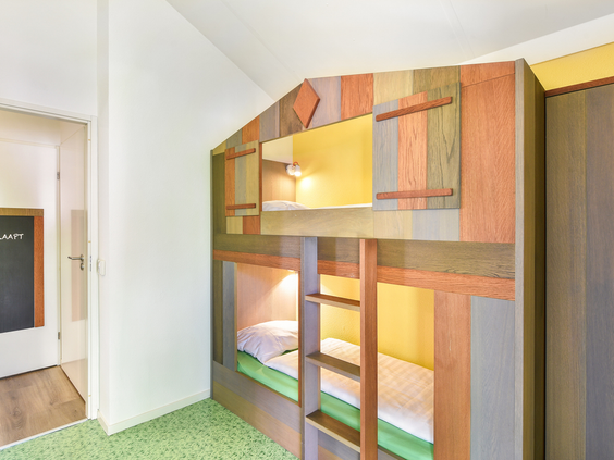 Vrolijke kinderslaapkamer met een kleurrijk stapelbed in een kinderbungalow van Landal Stroombroek.