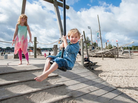 Een jongen zoeft van de kabelbaan in de speeltuin op het strand bij Landal Travemünde aan de Oostzee.