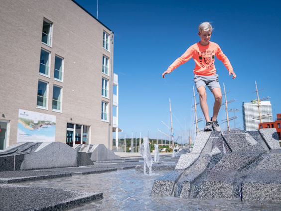 Een jongen balanceert op een modern speeltoestel op de promenade van Landal Travemünde.