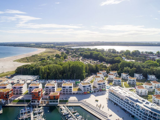 Luchtfoto van vakantiepark Landal Travemünde, met de vakantiehuizen gelegen aan de jachthaven en de Oostzeekust.