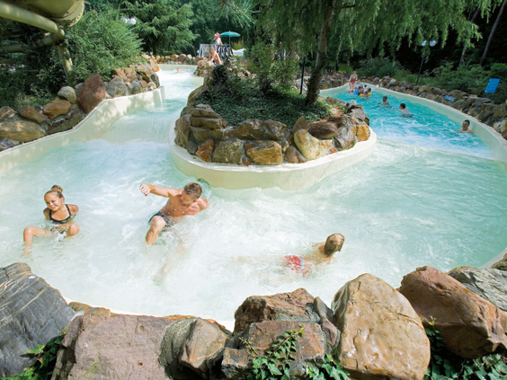 Gasten dobberen in het warme water van de wildwaterbaan bij Landal Het Vennenbos