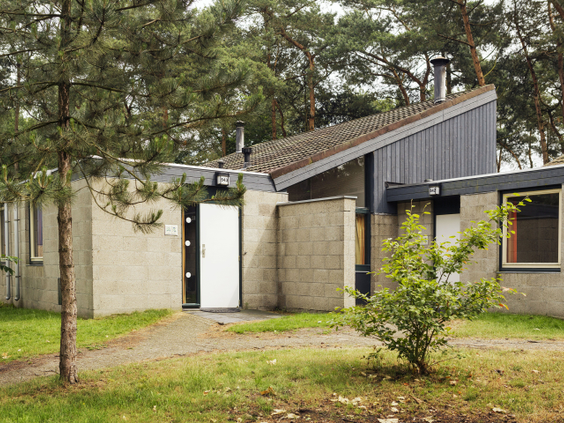 De buitenkant van een comfortabele bungalow, gelegen tussen de dennenbomen op het bosrijke vakantiepark Landal Vennenbos in Noord-Brabant.