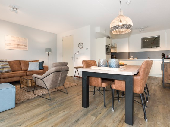 Overzicht van het modern en sfeervol ingerichte appartement op Landal Vitamaris, met een open keuken, eethoek en zithoek.