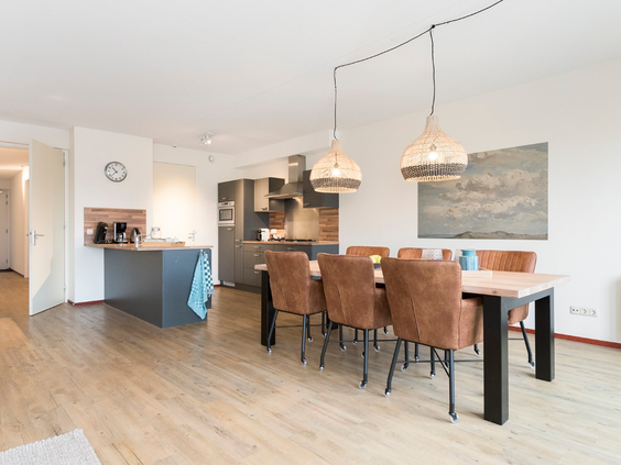 De moderne open keuken met kookeiland en de ruime eethoek in een appartement van Landal Vitamaris op Schiermonnikoog.