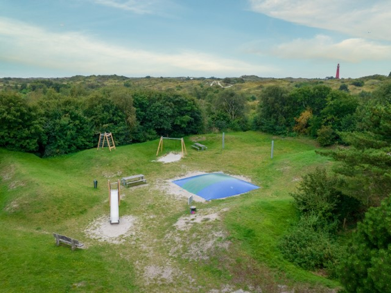 Luchtfoto van de speeltuin van Landal Vitamaris, met een airtrampoline en glijbaan, gelegen in een duinpannetje op Schiermonnikoog.