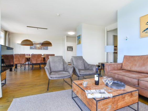 De luxe en ruime zithoek in een appartement op Landal Vitamaris, met een leren bank, comfortabele fauteuils en een houten salontafel.