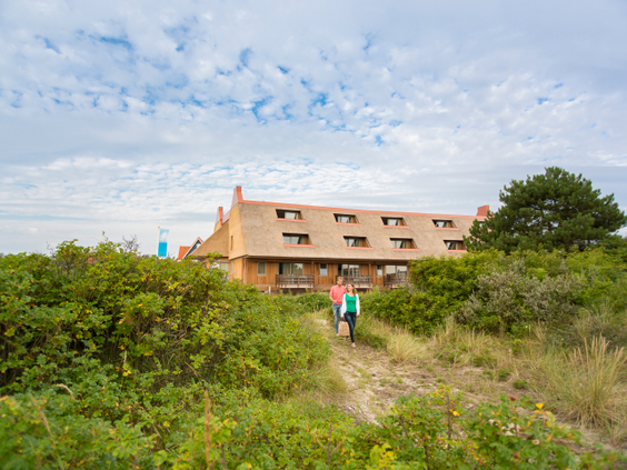 Het appartementengebouw van Landal Vlieduyn, prachtig gelegen midden in het groene duinlandschap van Vlieland.