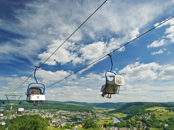 De stoeltjeslift (Sessellift) van Landal Warsberg die van de berg naar beneden gaat, met een weids uitzicht over het stadje Saarburg.