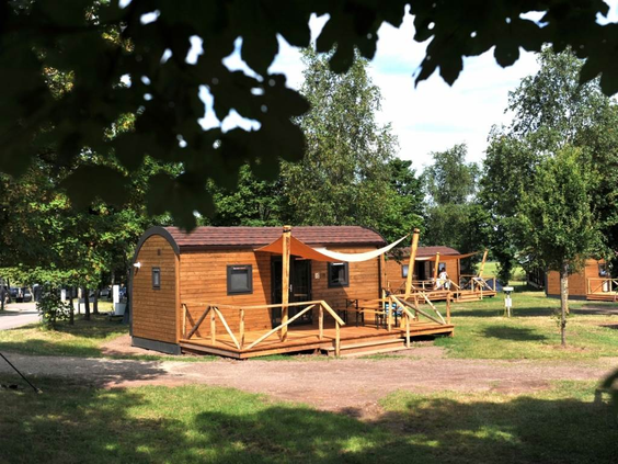 De buitenkant van een moderne en knusse Woodlodge, een houten glamping-accommodatie op de camping van Landal Warsberg.