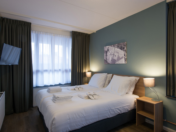 De comfortabele slaapkamer met een netjes opgemaakt tweepersoonsbed in een appartement van Landal Waterparc Veluwemeer.
