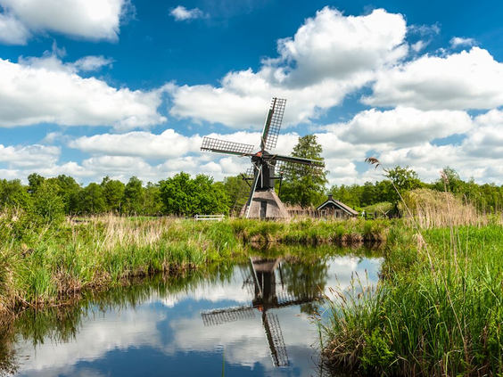 Een typisch Hollandse molen (tjasker) in het waterrijke rietlandschap van Nationaal Park Weerribben-Wieden.