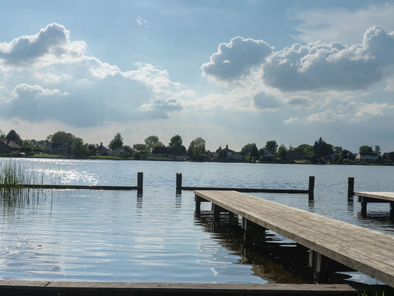 Een houten aanlegsteiger aan een rustig meer bij Landal Waterresort Blocksyl, perfect om te vissen of te zwemmen.