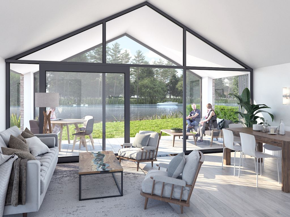 Het lichte en ruime interieur van een watervilla op Landal Waterresort Blocksyl, met een glazen pui die uitzicht biedt op het water.