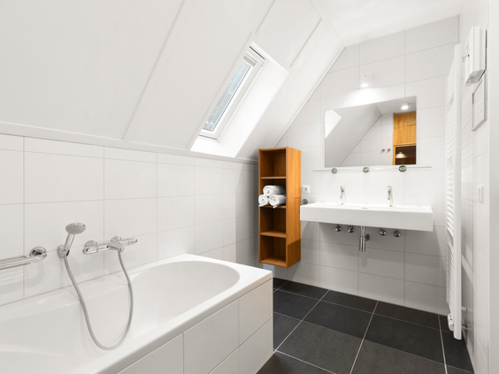 Lichte en moderne badkamer in een vakantiehuis op Landal Waufsberg, voorzien van een ligbad en dubbele wastafel.