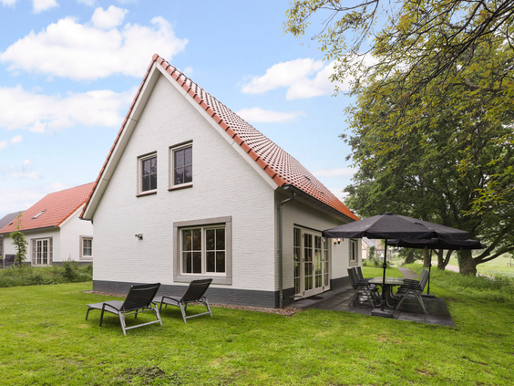 Vrijstaand wit vakantiehuis met een ruime tuin, terras met tuinmeubilair en ligbedden op Landal Waufsberg.