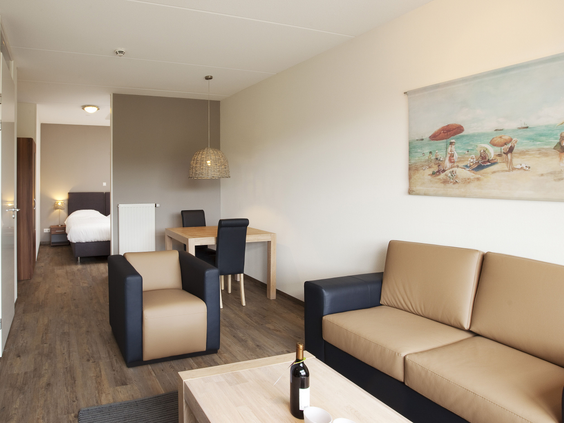 De knusse inrichting van een studio appartement bij Landal West-Terschelling, met een zithoek en eethoek.