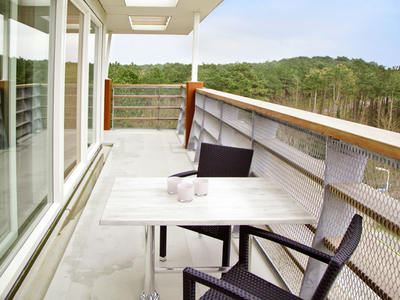 Het balkon van een modern appartement bij Landal West-Terschelling, met uitzicht op de duinen van Terschelling.