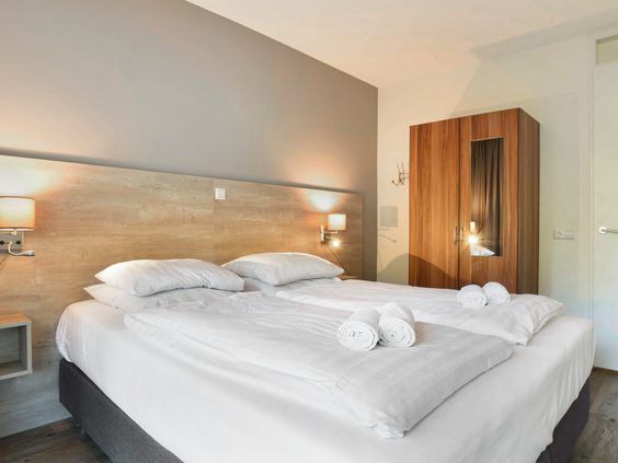 De comfortabele slaapkamer in een appartement van Landal West-Terschelling, met een net opgemaakt tweepersoonsbed.