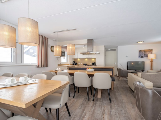 Het moderne en lichte interieur van een vakantiehuis op Landal Winterberg, met een ruime eettafel en een gezellige zithoek.