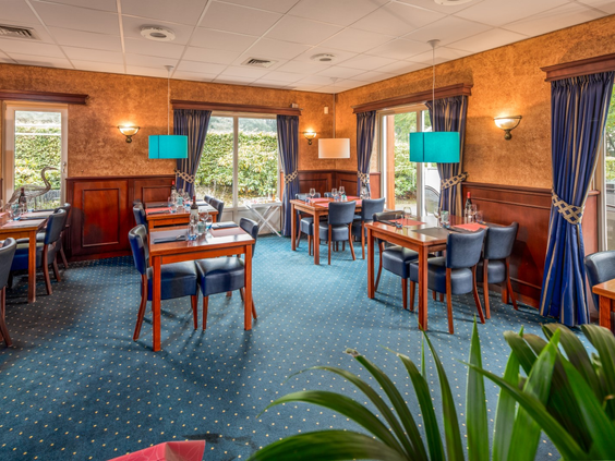 Het gezellige restaurant van Landgoed het Grote Zand, met gedekte tafels die uitkijken op het groen.