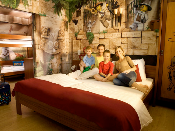 Thematische avonturen-hotelkamer met gezin, stapelbed en LEGO decoraties, geïnspireerd op Egypte of jungle, in het LEGOLAND Feriendorf.