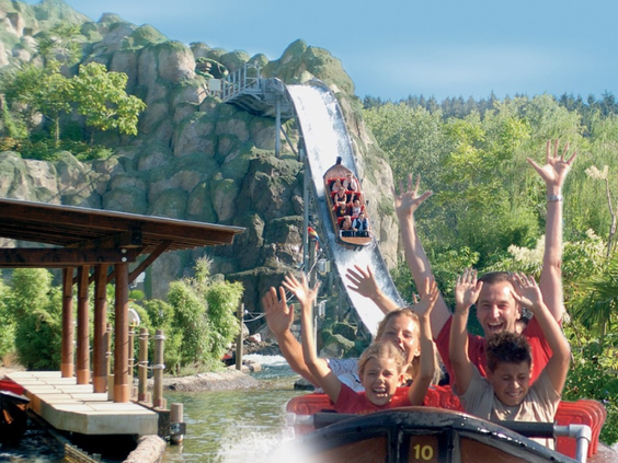 Gezin joelend van plezier in een wildwaterbaan attractie in LEGOLAND Duitsland, met opspattend water