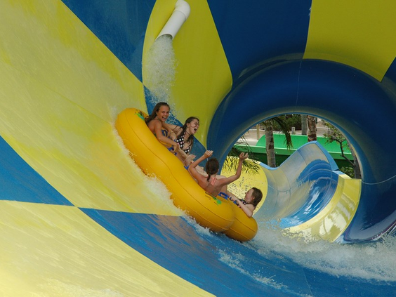 Een groep mensen die in een grote band van een spectaculaire blauw-gele waterglijbaan glijdt in waterpark Aquadome in Lalandia.
