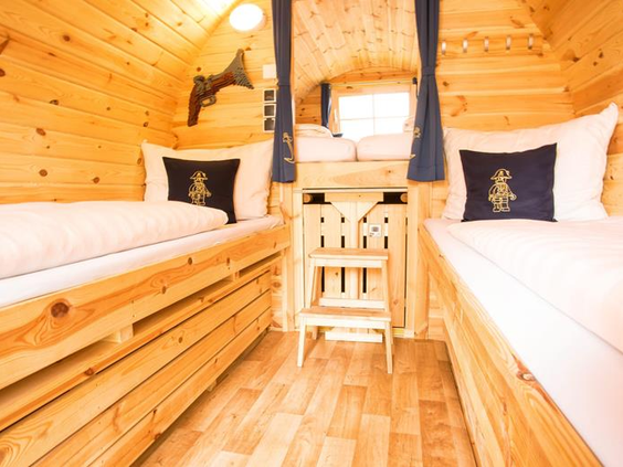 Het knusse houten interieur van een Piraten themakamer in LEGOLAND Holiday Village, met twee opgemaakte bedden en piratendecoratie.
