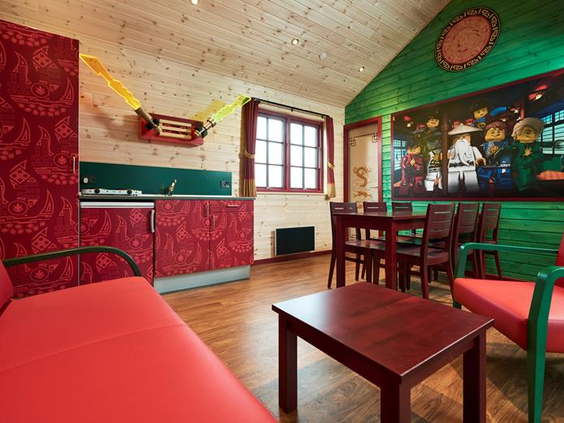 De kleurrijke woonkamer van een LEGO® NINJAGO® Cabin in LEGOLAND Holiday Village, met een grote muurschildering van de ninja's.