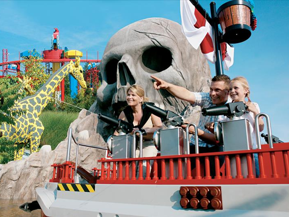 Een gezin in de waterattractie Captain Nick's Splash Battle in LEGOLAND Duitsland, varend langs een gigantische piratenschedel.