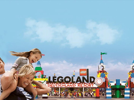 Een moeder en dochter lachen bij de kleurrijke ingang van LEGOLAND Deutschland Resort in Beieren.