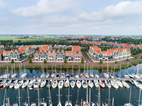 Uitzicht op de drukke jachthaven van Marinapark Volendam vol met zeilboten, direct gelegen voor de vakantiehuizen.