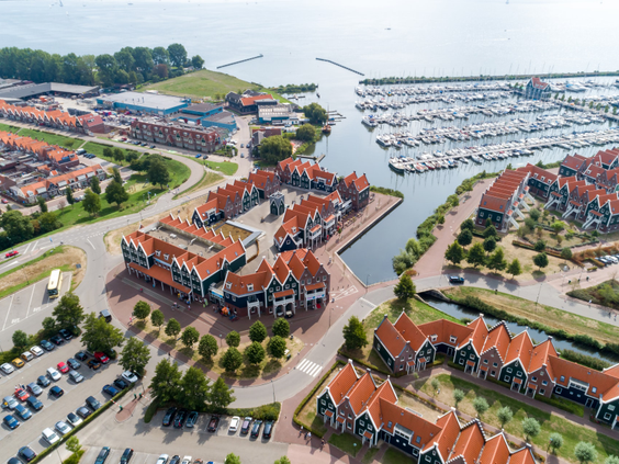 Een luchtfoto van het uitgestrekte Marinapark Volendam, dat laat zien hoe de vakantiehuizen en de jachthaven direct aan het Markermeer liggen.
