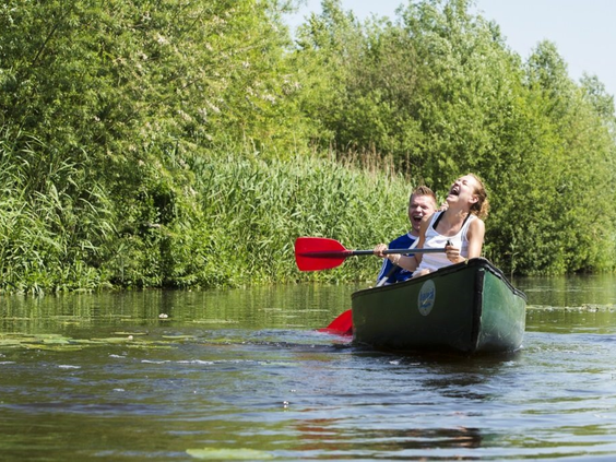 Een koppel peddelt in een kano op de rivier de Slinge bij Marveld Recreatie in de Achterhoek.