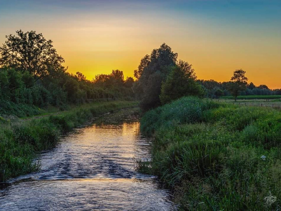 De rivier de Slinge in de Achterhoek stroomt door het landschap bij Marveld Recreatie tijdens een prachtige zonsondergang.