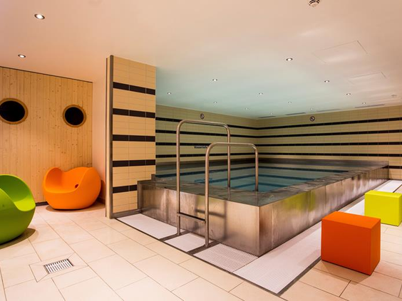 De vrolijk gekleurde speelruimte voor kinderen in het Mercure Hotel Duisburg City, met zachte poefjes en speelelementen.