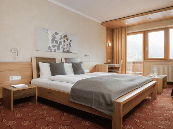 Tweepersoonsbed in appartement met uitzicht op de bergen