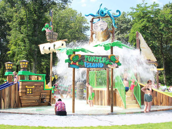 De avontuurlijke waterspeeltuin 'Turtle Island' in Waterspeelpark Splesj, met een piratenschip, glijbanen en een grote omkiepende waterton.