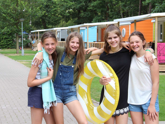 Vier lachende tienermeiden poseren voor de foto op Molecaten Park Bosbad Hoeven, klaar voor een dag vol waterpret.