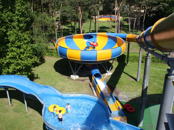 De spectaculaire waterglijbaan 'De Trechter' in Waterspeelpark Splesj, waar kinderen met een band door een grote geel-blauwe trechter glijden.