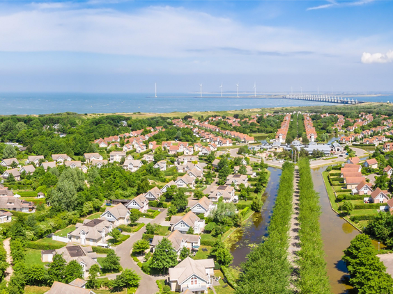 Een luchtfoto van het ruim opgezette Noordzee Résidence De Banjaard, met de luxe villa's en de ligging nabij het Noordzeestrand in Zeeland.