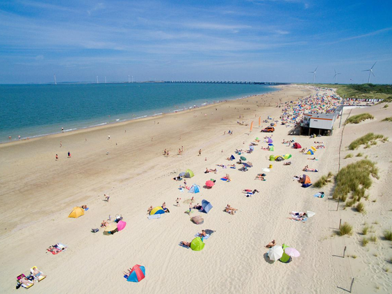 Luchtfoto van het brede en schone Banjaardstrand, direct gelegen bij Noordzee Résidence De Banjaard, met veel ruimte om te spelen en zonnen.