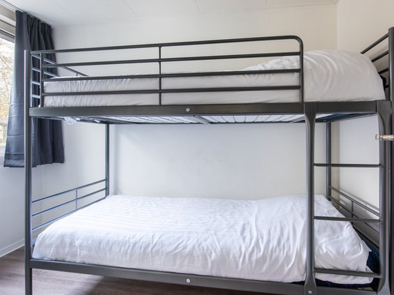 Een kinderslaapkamer met een modern, zwart metalen stapelbed in een vakantiehuis op Parc de Berkenhorst.