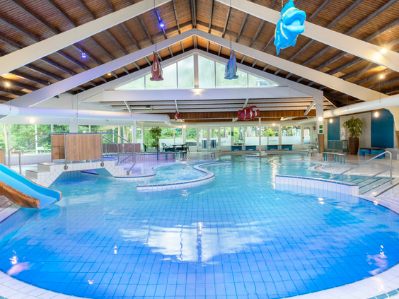 Overzicht van het subtropische zwemparadijs Aqua Mundo op Parc Heihaas, met een groot zwembad en glijbaan.